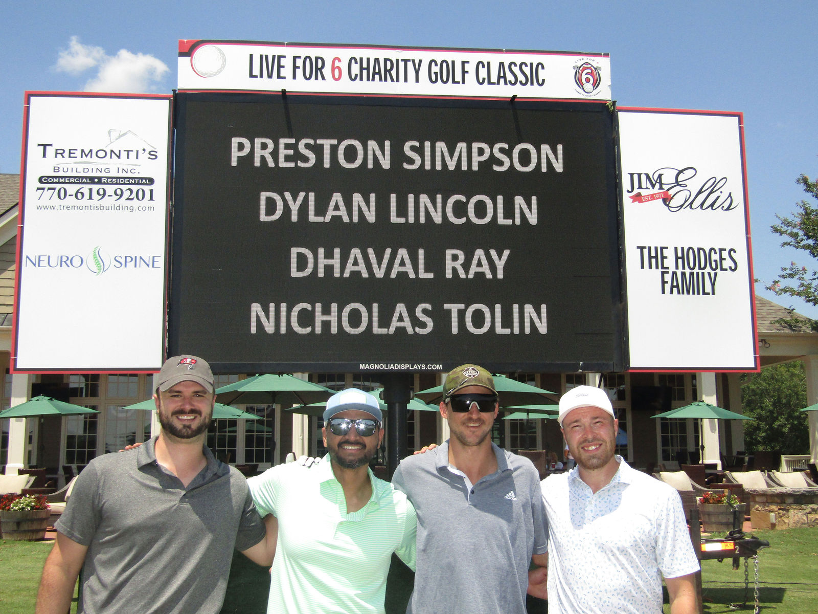 Another golf team gathered at the Live for 6 scoreboard